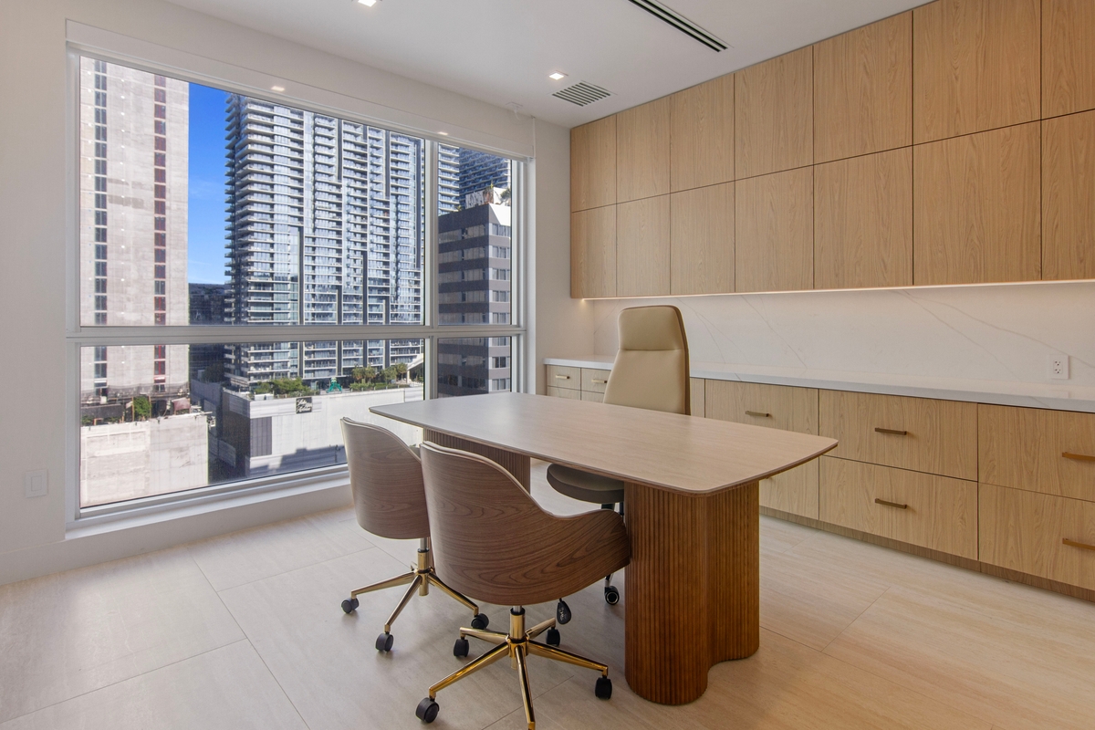 Second private office with oak wall paneling, built-in credenza and skyline outlook