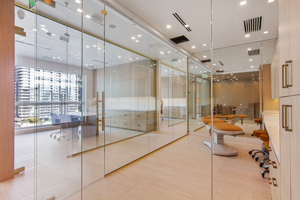 Glass-enclosed aesthetic and Med Spa treatment area with treatment chairs and skyline exposure