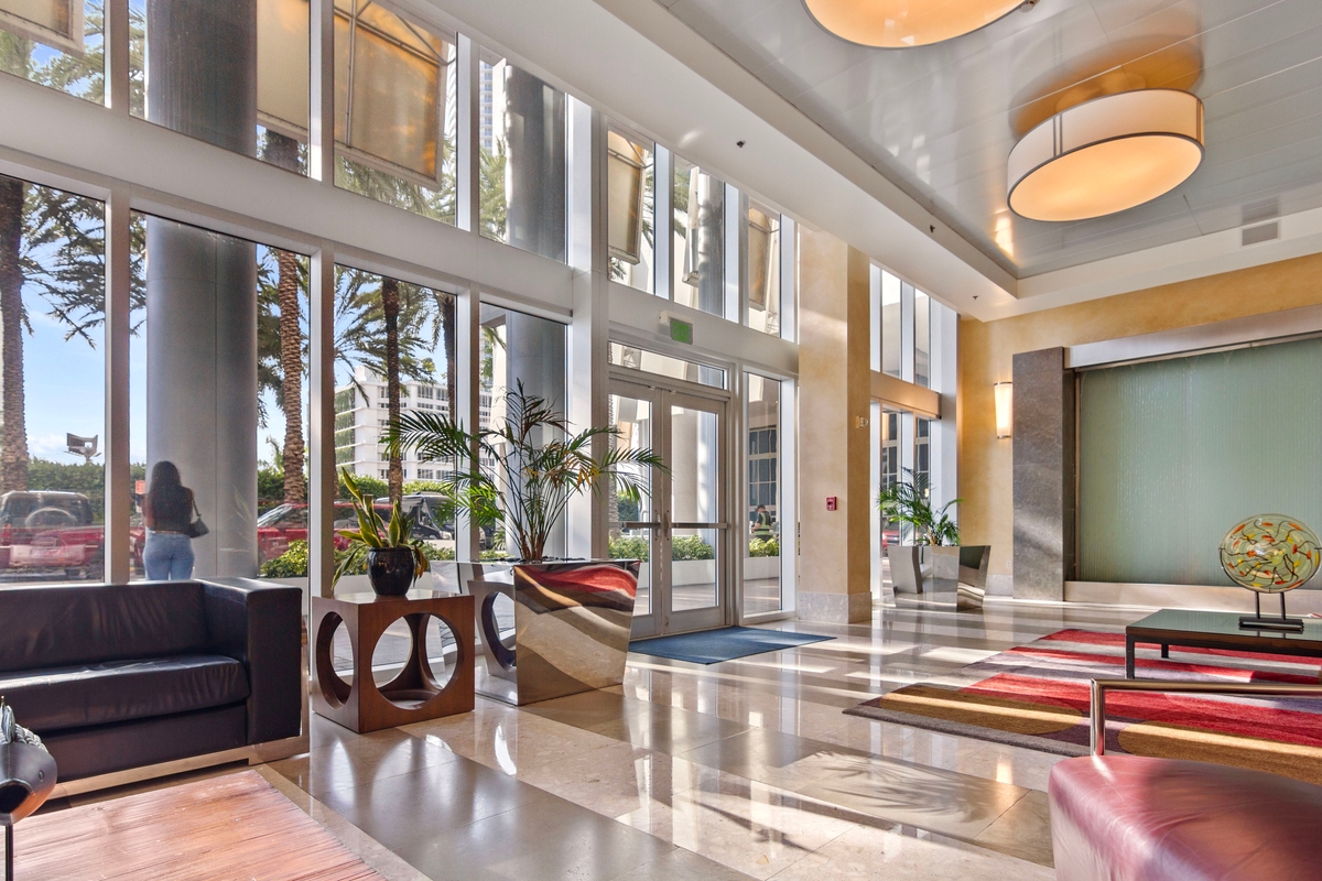 Latitude One residential and commercial lobby with double-height ceilings and stone floors