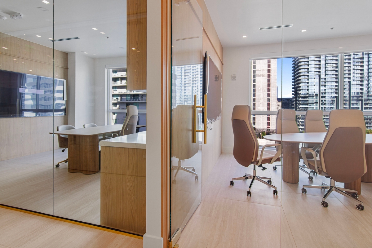 Private executive office furnished with desk, task seating and floor-to-ceiling glazing