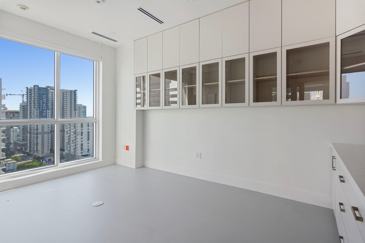 Procedure room perimeter cabinetry with glass upper cabinets and natural light along the window wall